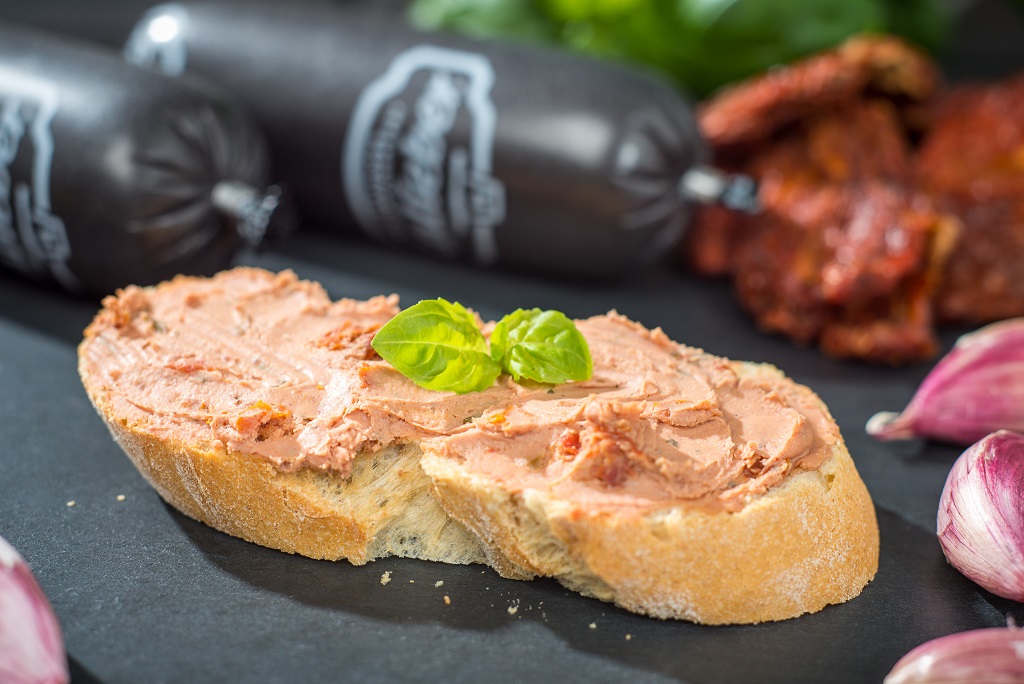 Sommer-Tomatenleberwurst vom Aktivstall-Schwein Brot mit Leberwurst, Wurst & Dekoration im Hintergrund