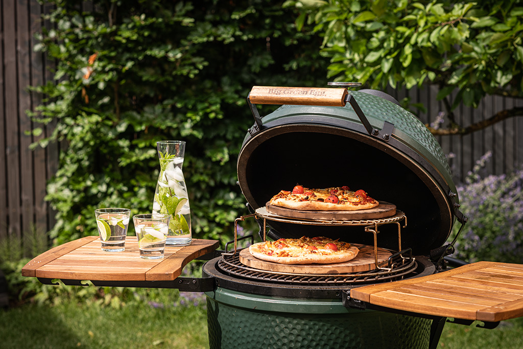 Big Green Egg Grill geöffneter Grill mit Rosten, Pizzasteinen und Pizza
