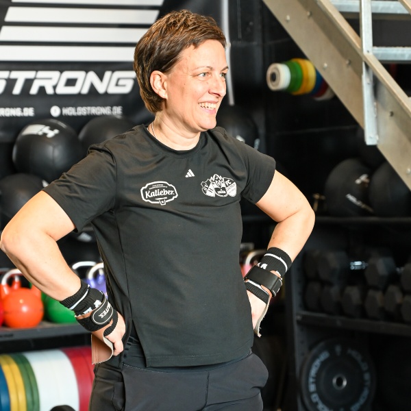 Sarah Dhem Gründerin Kalieber Sport Lächelnde Sportlerin im Fitnessstudio
