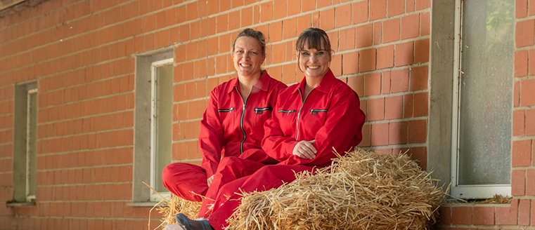 Sarah Dhem & Gabriele Mörixmann sitzen auf einem Strohballen
