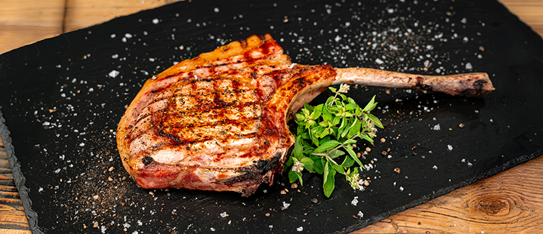 gegrilltes Tomahawk auf Teller angerichtet