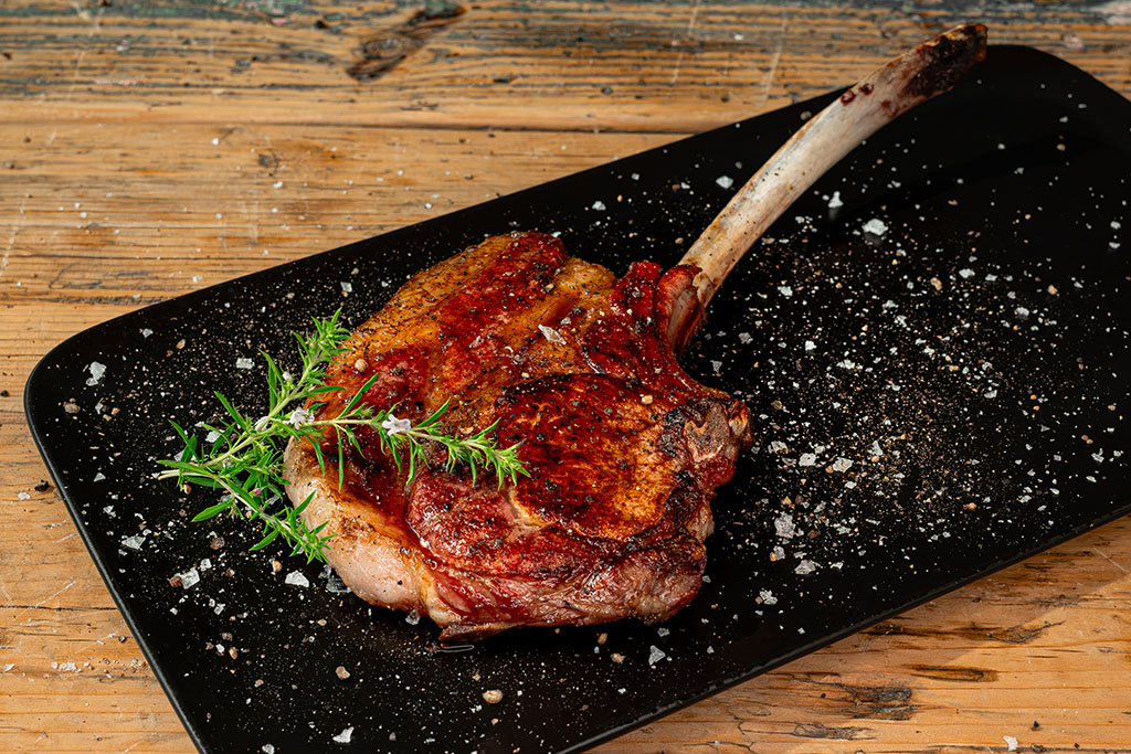 gegrilltes Tomahawk-Steak auf Teller angerichtet