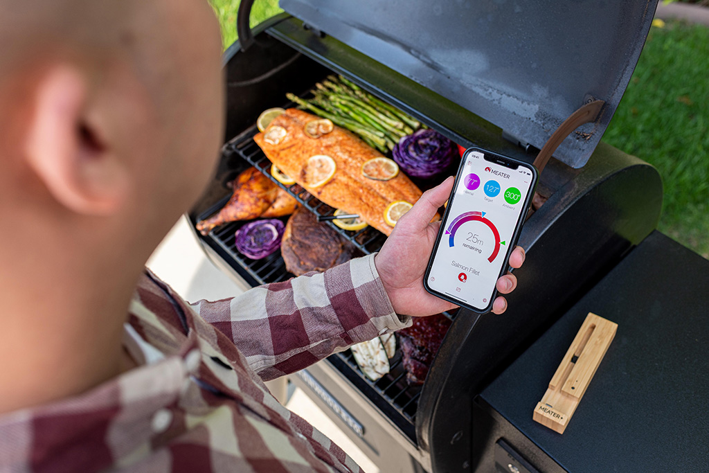 MEATER Fleischthermometer Mann am Grill mit MEATER Fleischthermometer + App