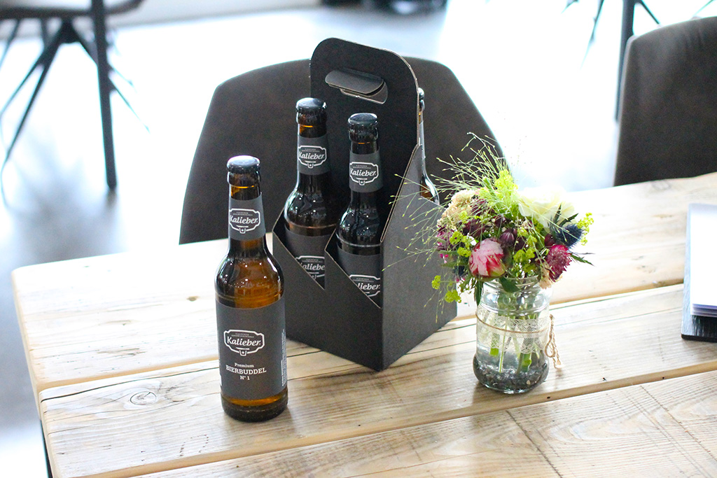 Kalieber Bierbuddel N° 1 als 4-er-Träger auf einem Tisch