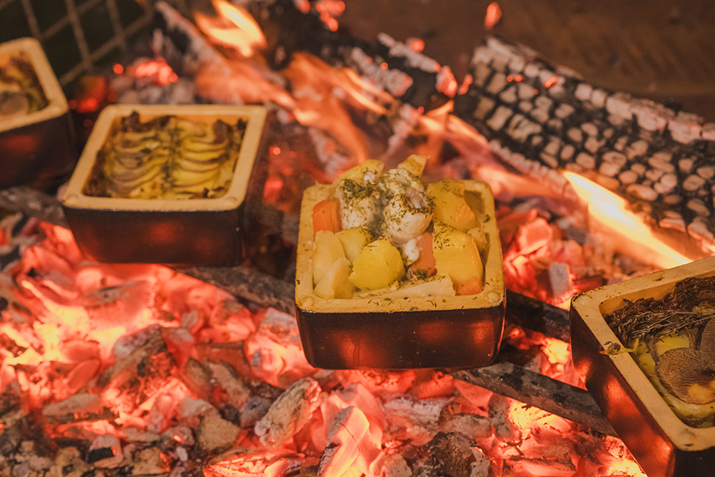 mehrere Bricknics mit Gemüse auf glühender Kohle