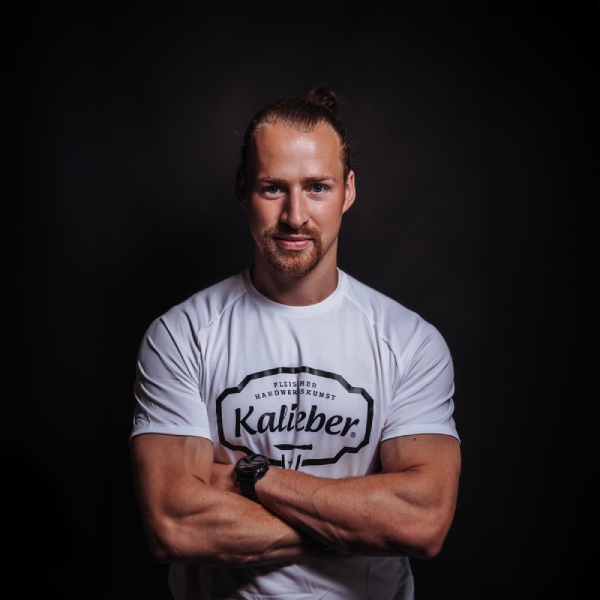 Sportlicher Mann mit weißem T-Shirt mit schwarzem Kalieber-Logo