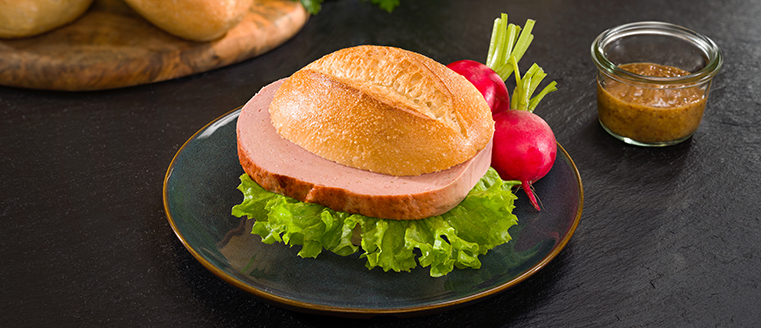 Brötchen mit Fleischkäse & Salat auf Teller
